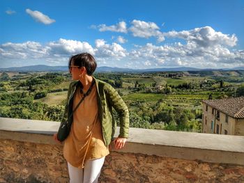 Young woman standing on landscape against sky