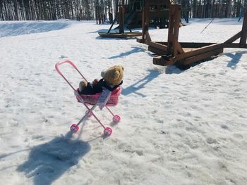 Girl playing on snow covered land