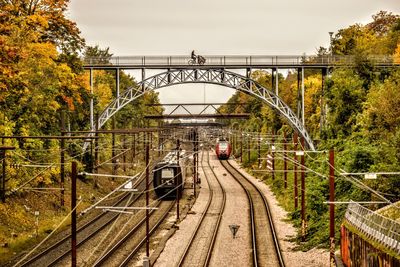 Railroad tracks by footbridge against sky