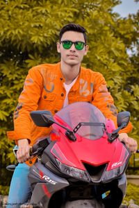 Young man riding sunglasses sitting on motorcycle