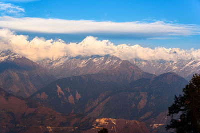 Scenic view of snowcapped mountains against cloudy sky