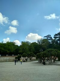 People playing in park against sky