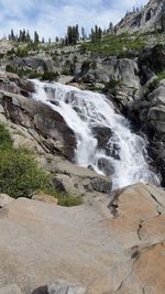 Scenic view of waterfall against sky