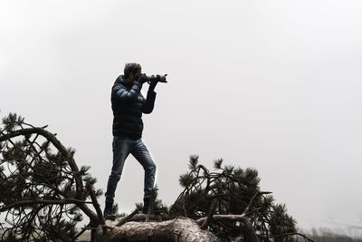 Man photographing against sky