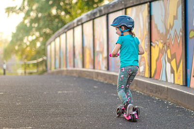 Full length of boy with umbrella on bicycle