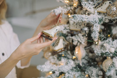 Midsection of woman decorating christmas tree at home