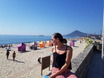 Full length of woman on beach against clear sky