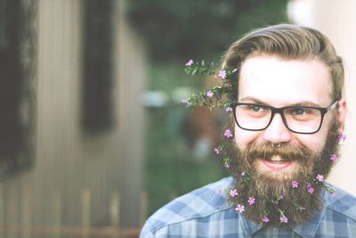 Close-up of smiling hipster wearing flowers