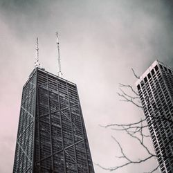 Low angle view of crane against cloudy sky