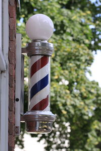 Low angle view of barber pole against trees