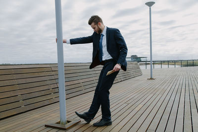 Full length of man on railing against sea