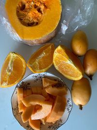 High angle view of orange fruits and pumpkin on table