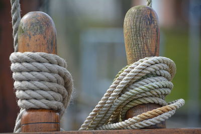 Close-up of ropes tied on wooden bollards