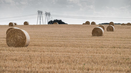 Hay bales on field against sky