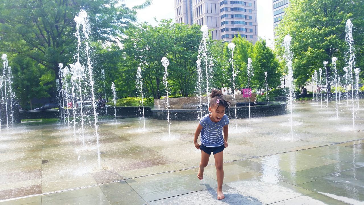 water, lifestyles, full length, leisure activity, casual clothing, tree, young adult, person, standing, motion, young women, day, front view, wet, outdoors, looking at camera, portrait, reflection