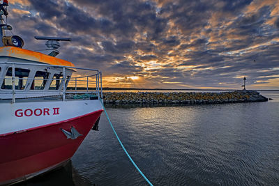 Boats moored on sea against sky during sunset