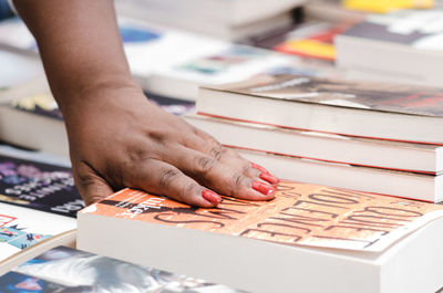 Cropped hand of woman holding book in library