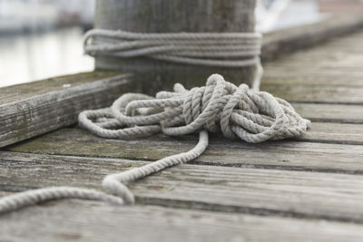 Close-up of rope tied to wooden pier