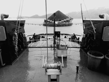 Boats moored at harbor against sky