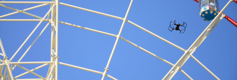 Low angle view of telephone pole against clear blue sky