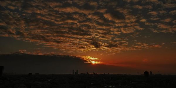 Scenic view of silhouette landscape against orange sky