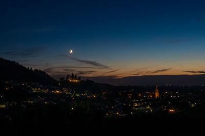 Illuminated city against sky at night