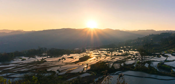 Scenic view of snowcapped mountains against sky during sunset