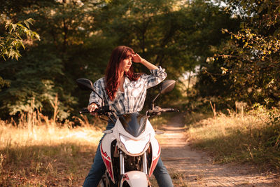 Woman riding motorcycle on field