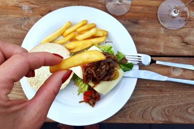 Close-up of hand holding food on table