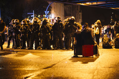 Group of people at illuminated street in city at night