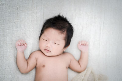 High angle view of baby sleeping on bed