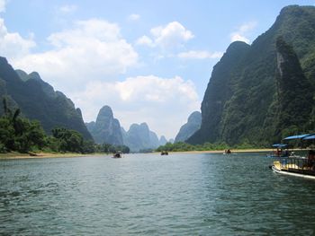 Scenic view of sea and mountains against sky