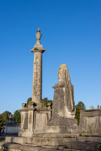 Low angle view of statue against blue sky