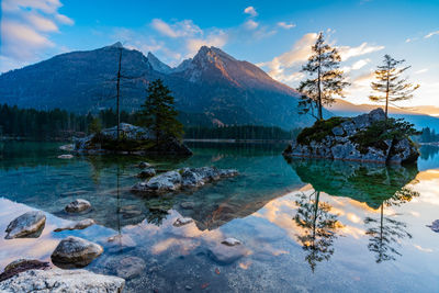 Scenic view of lake by snowcapped mountains against sky