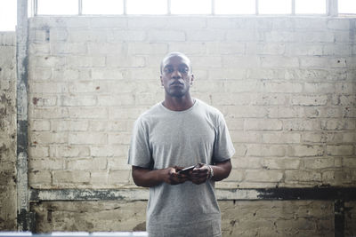 Full length of young man standing against wall