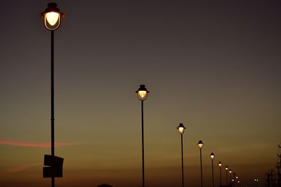 Low angle view of illuminated street light against sky