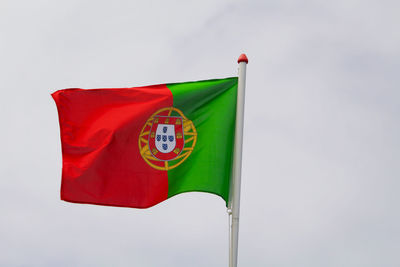 Low angle view of red flag against sky