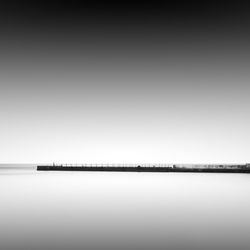 Pier amidst sea against sky during foggy weather