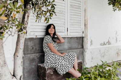Portrait of woman sitting against plants
