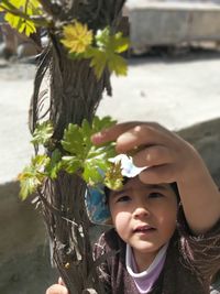 Portrait of boy holding plant