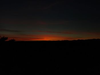 Silhouette landscape against sky at sunset