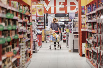 Father with daughters doing shopping in supermarket