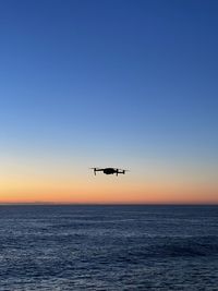 Drone flying over sea during sunrise 