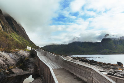 Footbridge leading towards mountains by river