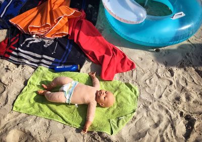 High angle view of doll on towel at beach