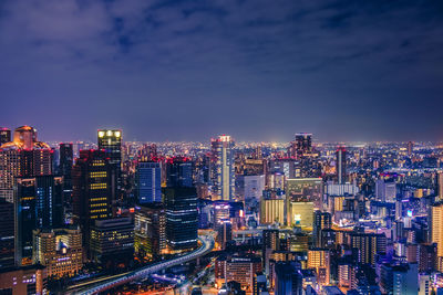 Illuminated buildings in city against sky at night