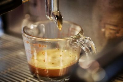 Close-up of coffee pouring in glass