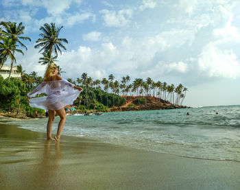 Girl enjoying the beach and palms