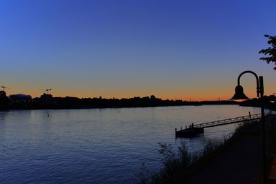 Scenic view of lake against clear sky during sunset