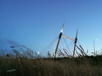 Windmills on landscape against blue sky